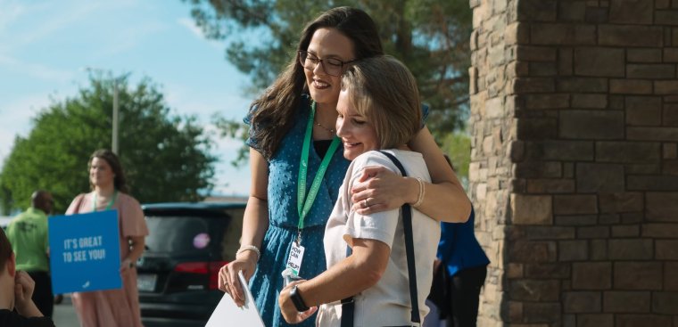 people hugging in front of the church