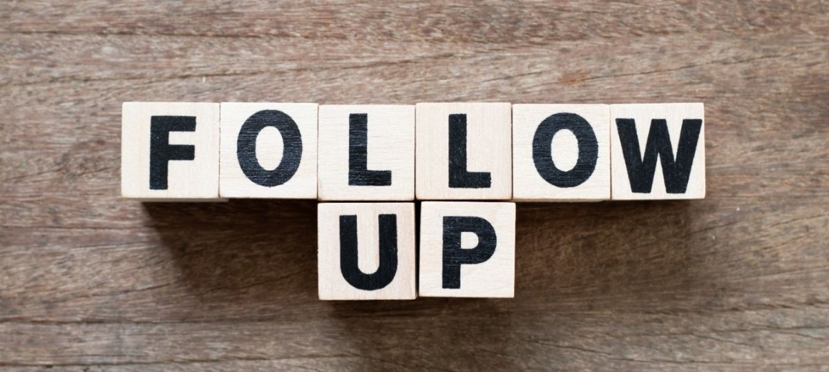 Wooden blocks arranged to spell the words "FOLLOW UP" against a wooden background. The blocks have black letters on them, creating a clear and straightforward message about the importance of following up.