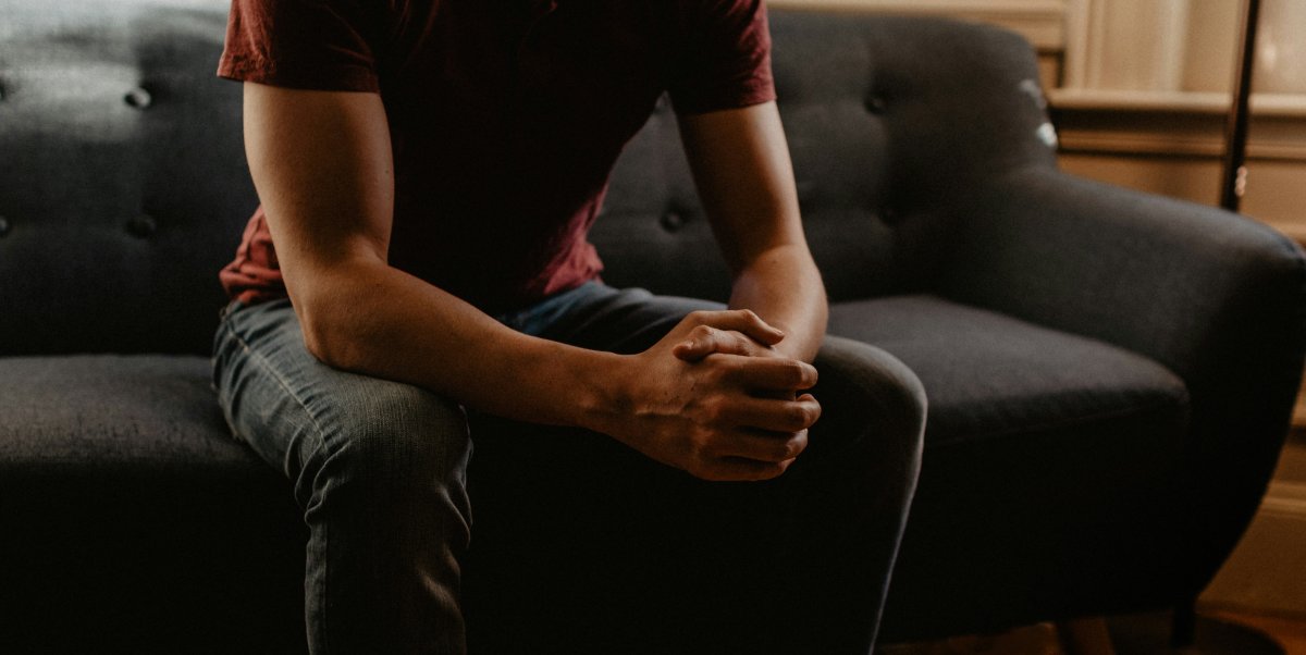 Man sitting on couch presumable ready to be counseled. 