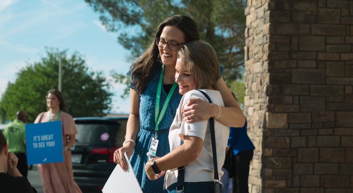 people hugging in front of the church