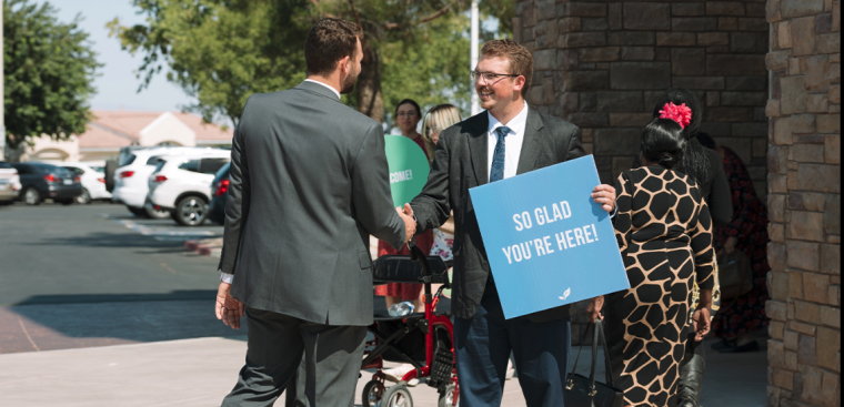 people shaking hands in front of church