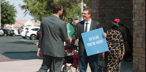 people shaking hands in front of church